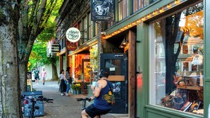 A street scene with a storefront named "Paxtongate" and a sign for "Margaret's." - Historic 2BR | Walk to NW 23rd Shops & Eats (Portland)