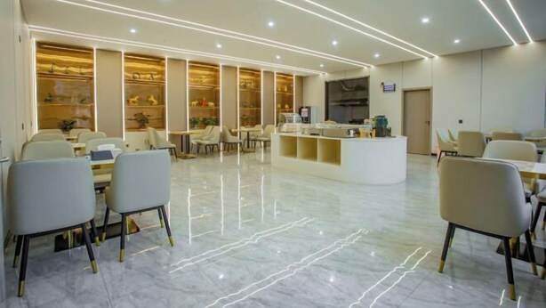 Una hall d'hotel moderna con reception, area salotto e una teca in vetro con oggetti esposti.