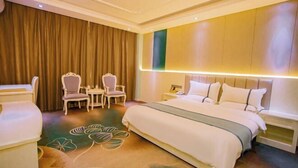 Una camera d'albergo con un letto, due sedie, un tavolino, un comodino e una tenda.