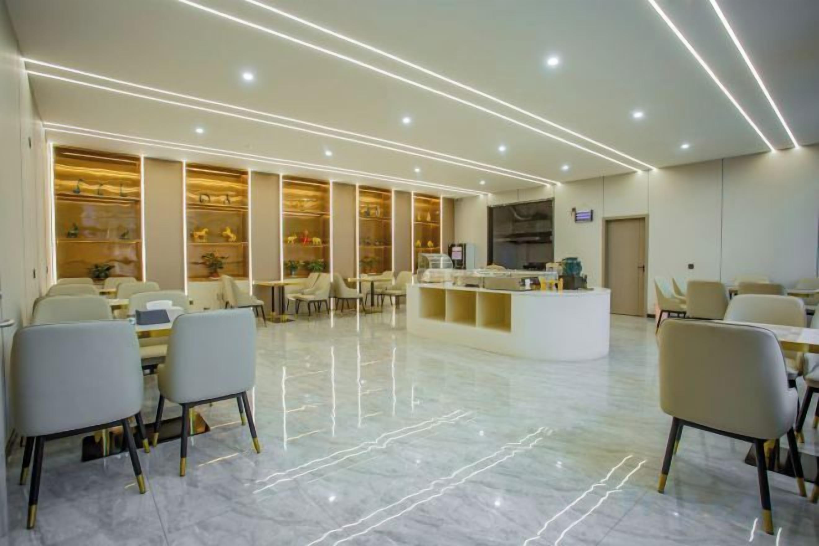 A hotel lobby with a reception desk, seating area, and a large window.
