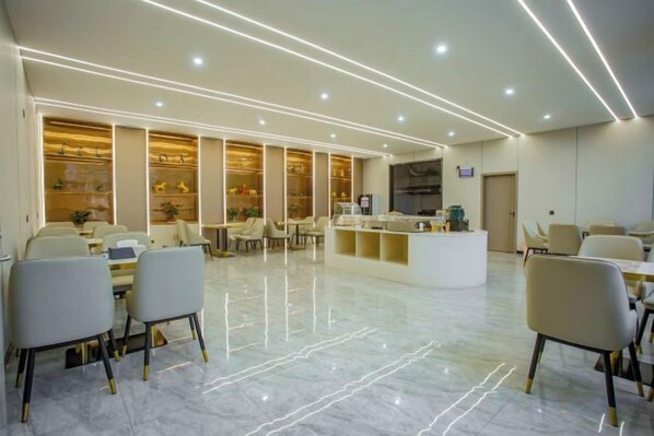 A hotel lobby with a reception desk, seating area, and a large window.