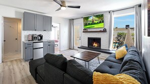 A modern living room with a fireplace, grey sofa, and a television. - PAPAGO PLACE - Spacious 5-bedroom house in South Scottsdale (Scottsdale)