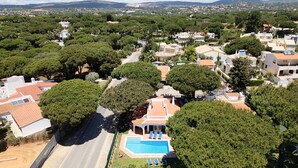 A residential area with houses, a swimming pool, and a road.