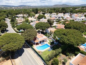 A residential area with houses, a swimming pool, and a road. - Villa Moura by HelloVacations (Loulé)
