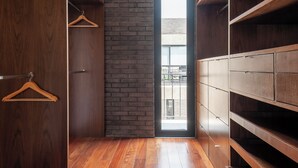 A modern closet with wooden shelves and a brick accent wall. - Queretaro 77 by Wynwood House (Mexico City)