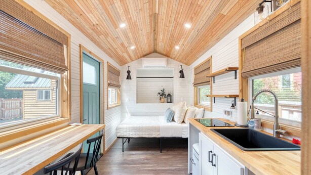 A compact kitchen with a sink, stove, and dining area. - Tiny Farmhouse - Walk to Local Shops & Restaurants (Portland)