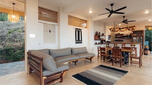 Een moderne woonkamer met een bank, eethoek en keuken.