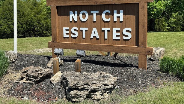 Un panneau en bois portant l’inscription « NOTCH ESTATES » en lettres blanches.