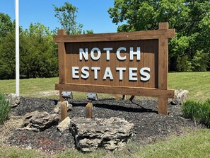Een houten bord met de tekst 'NOTCH ESTATES' in witte letters.