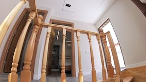 Een houten trap met een gebogen plafond, die naar een verdieping leidt.