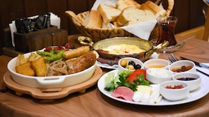 Een tafel met diverse gerechten, waaronder brood, dips en een kom soep.