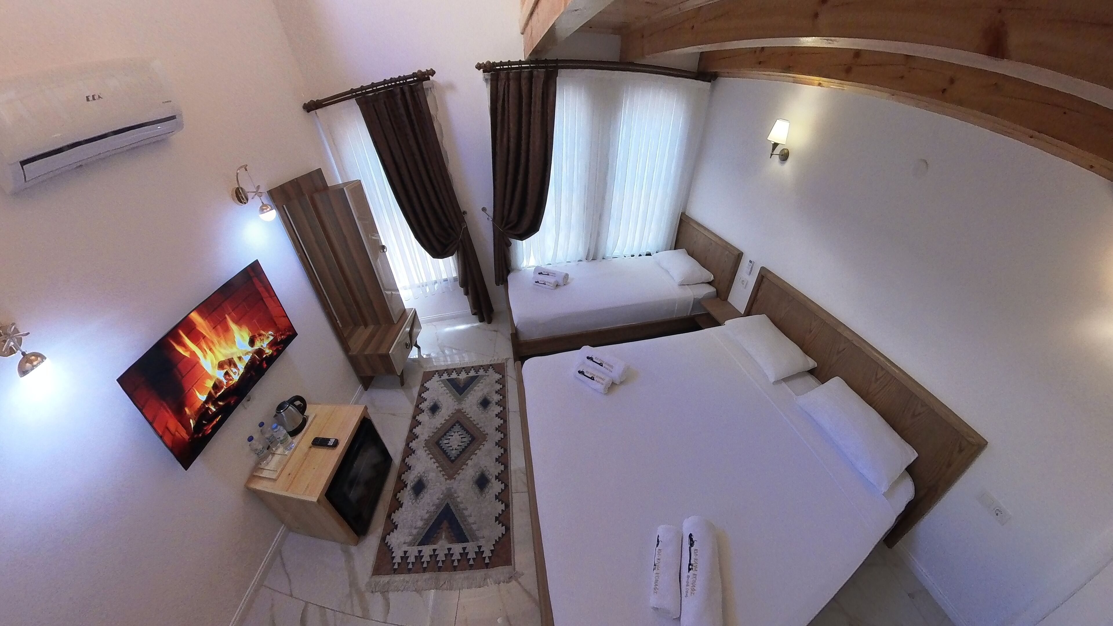 A room with a bed, a TV, a coffee table, and a wall-mounted air conditioner.