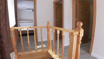 Una scala in legno con corrimano che porta a un pianerottolo.