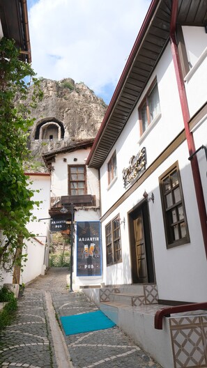 A narrow cobblestone street with a pub named 'Arjantin Pub' and a building with a sign 'Kova'.