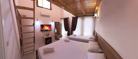 Una habitación acogedora con dos camas, televisión, chimenea y una escalera de madera.