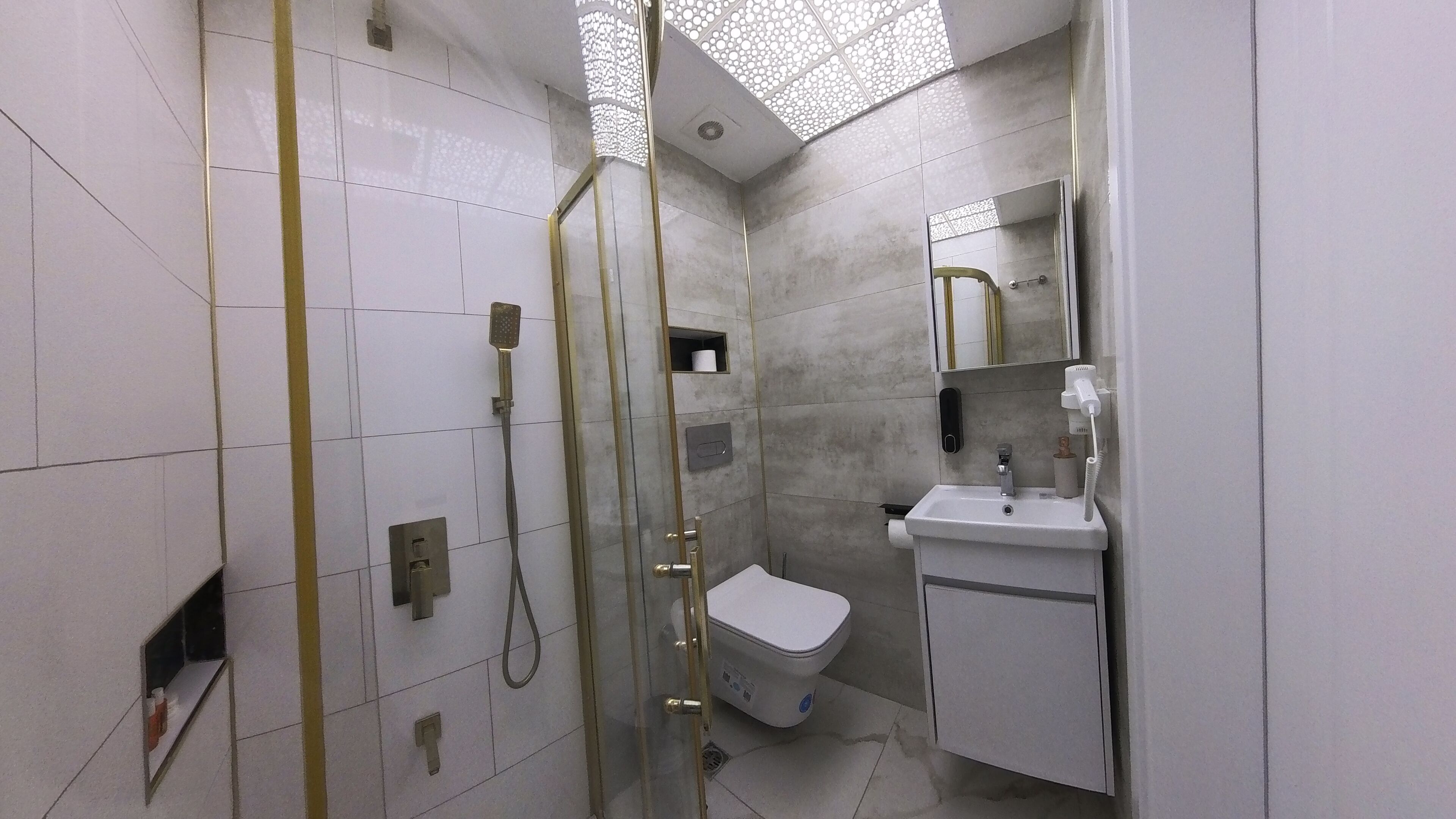 Un bagno moderno con doccia, WC e lavandino.