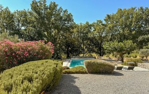 A pool area with a clear blue pool, surrounded by well-maintained hedges and trees. - Nice home in Salernes (Salernes)