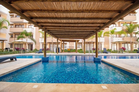 Una piscina al aire libre, camas de piscina gratis, sombrillas