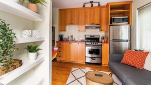 A modern kitchen with wooden cabinets, stainless steel appliances, and a built-in microwave shelf. - Perfect Hawthorne Micro By Top Shopping & Dining (Portland)