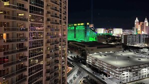 A high-rise hotel with multiple floors, a parking garage, and a casino with green lighting. - MGM 1 Bedroom Balcony And Or Studio Luxury Suites (Las Vegas)