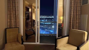 A hotel room with a balcony overlooking a cityscape at night. - MGM 1 Bedroom Balcony And Or Studio Luxury Suites (Las Vegas)