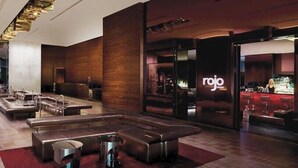Een moderne lobby met zithoeken en een bar genaamd 'rojo'.