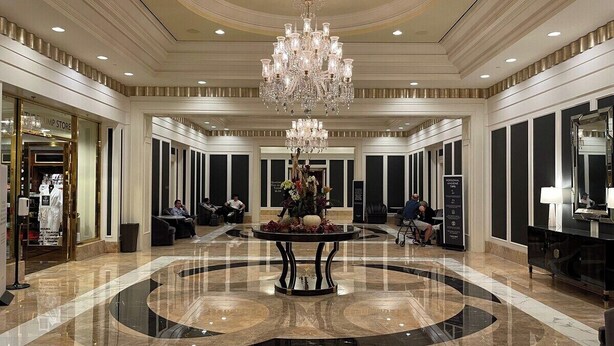 Un hall d’entrée spacieux, doté d’une grande table ronde au centre, d’un lustre imposant et d’un design moderne.