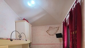 Ein kleiner, kompakter Raum mit Etagenbett, einem Einzelbett und einem Schreibtisch.