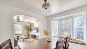 A dining area with a wooden table and chairs, a vase with leaves, and a ceiling fan. - Modern 3BR + sofa bed• Alberta Arts • WalkScore 99 (Portland)