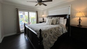 A bedroom with a bed, ceiling fan, two bedside lamps, and a window with curtains. - Awesome 4 Bedroom, 3 1/2 Bath Home 1/2 Mile Walk To Disney (Anaheim)