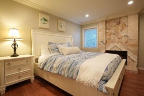 A bedroom with a bed, nightstand, lamp, and artwork on the wall. - Large Family Pool Home 2.5 Miles To Disney w/3 King Beds!!! (Anaheim)