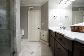 A bathroom with a white door, a white sink, a mirror, and a basket on the counter. - Incredible Estate 5 Bedrooms 3 Bathroom W/resort Style Rock Pool & Jacuzzi (Fullerton)