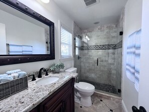 A bathroom with a large mirror, two sinks, a toilet, and a shower with a tiled wall. - Fabulous 6 Bedroom , 4 Bath Pool W/jacuzzi Home (Orange)