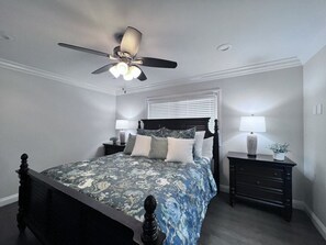 A bedroom with a bed, a ceiling fan, a nightstand with a lamp, and a window with blinds. - Fabulous 6 Bedroom , 4 Bath Pool W/jacuzzi Home (Orange)