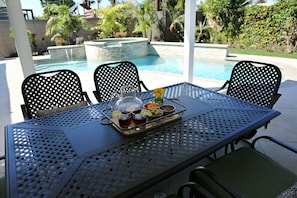 A poolside table with chairs, a tray of drinks, and a pitcher. - Fabulous 6 Bedroom , 4 Bath Pool W/jacuzzi Home (Orange)