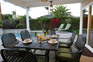 An outdoor patio with a pool table, chairs, and a dining setup. - Fabulous 6 Bedroom , 4 Bath Pool W/jacuzzi Home (Orange)