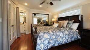 A bedroom with a bed, a ceiling fan, a mirror, and a window. - 5 Bedroom 4 Bath Pool Home Near Disney (Anaheim)