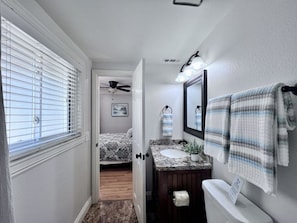 A bathroom with a vanity, a toilet, a towel rack, and a shower area. - 5 Bedroom 4 Bath Pool Home Near Disney (Anaheim)