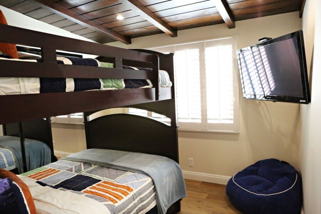 A bunk bed room with a television and a bean bag.