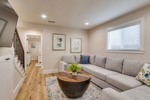 A living room with a sofa, a coffee table, and artwork on the walls.