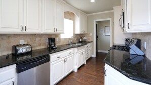 A kitchen with white cabinets, a dishwasher, a stove, and a toaster. - Classy 4 Bedroom 3 Bath Pool Home 3/4 Mile Walk To Disney (Anaheim)