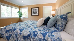 A bedroom with a large bed, a potted plant, a framed picture, and a window with blinds. - Classy 4 Bedroom 3 Bath Pool Home 3/4 Mile Walk To Disney (Anaheim)