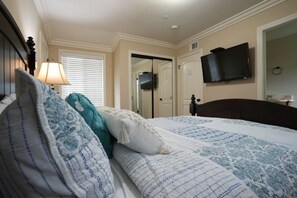 A bedroom with a bed, a television mounted on the wall, and a door leading to another room. - Comfy Pool Home,1/4 Mile Walk To Disneyland (Anaheim)