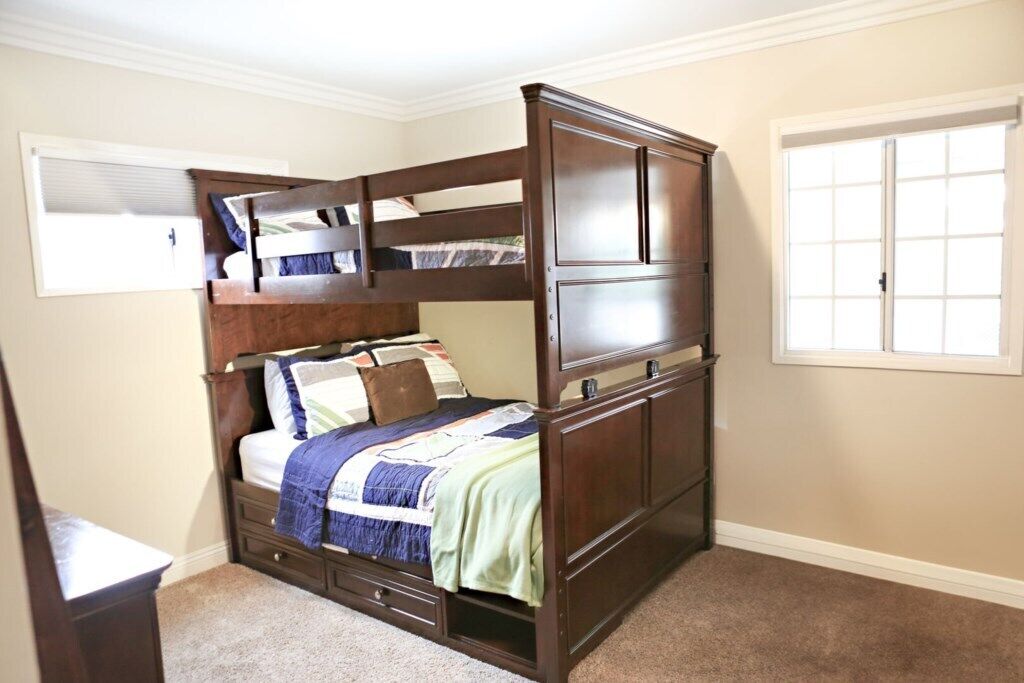 Une chambre à coucher avec un lit à baldaquin, une fenêtre et une commode.