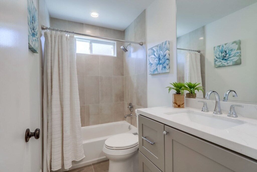 A bathroom with a bathtub, toilet, sink, and shower curtain.