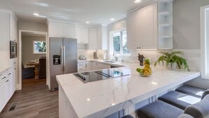A modern kitchen with white cabinetry, a central island, and a built-in oven.