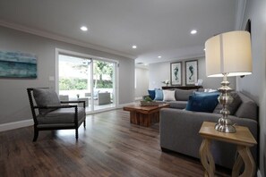 Un salon avec un canapé, un fauteuil, une table basse et une lampe.