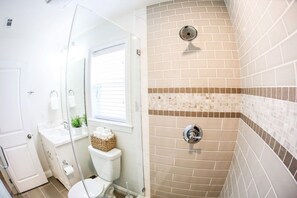 Ein Badezimmer mit Dusche, Toilette und Waschbecken sowie einer Duschkabine aus Glas.