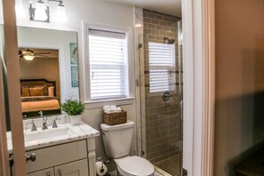 A bathroom with a toilet, sink, and shower. - Adorable 3 Bedroom 2 Bath Home (Fullerton)