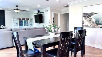 A dining area with a table, chairs, and a ceiling fan.